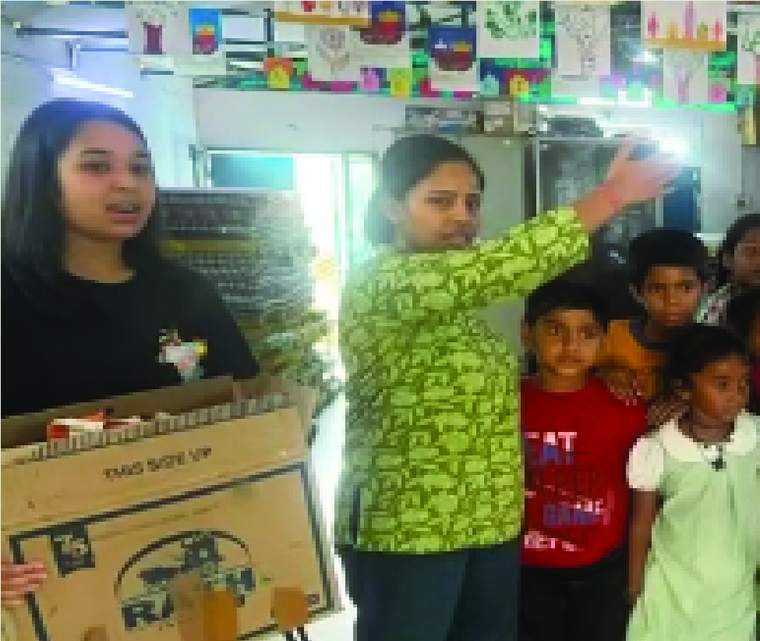 Handing over a box of donated clothes to children at a community centre
